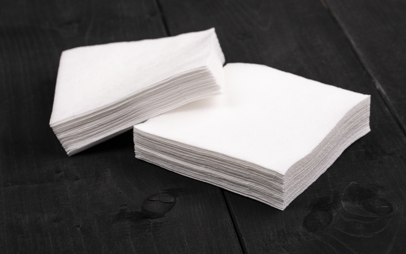 Рука с салфеткой. Мягкая бумага белая. Белизна бумаги 162%. Белизна бумаги ISO. Класс белизны бумаги